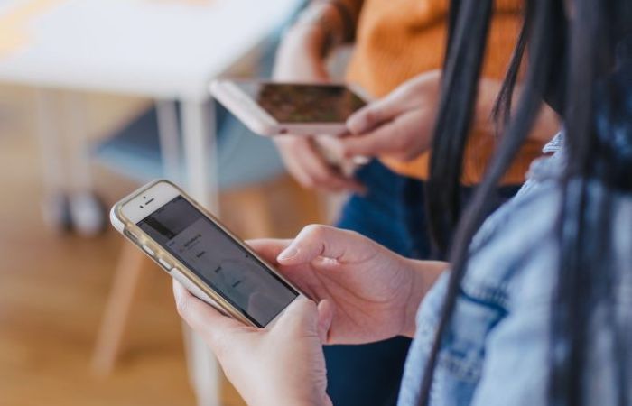 Two people, faces not shown, holding mobile phones